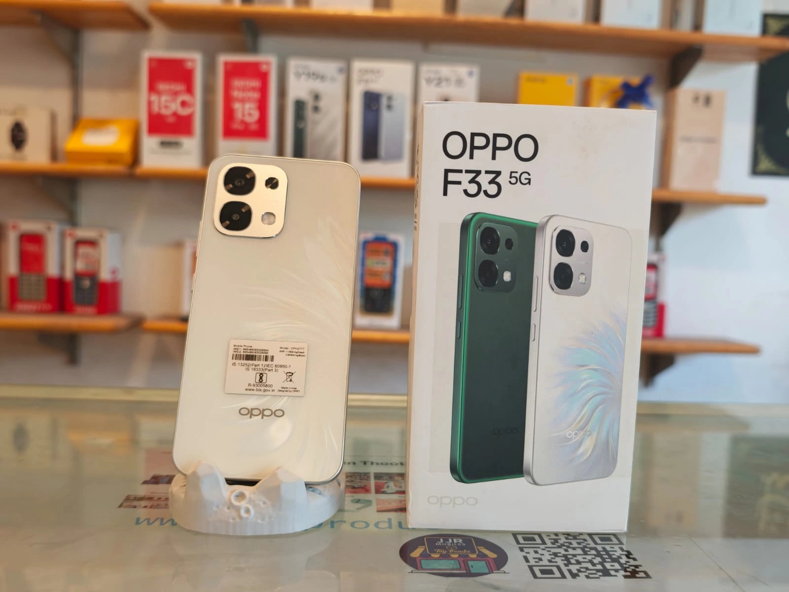OPPO F33 5G Pearl White smartphone displayed with retail box, featuring 50MP AI dual rear camera, 16MP selfie camera, Dimensity 6360 MAX processor, and 7000mAh battery.