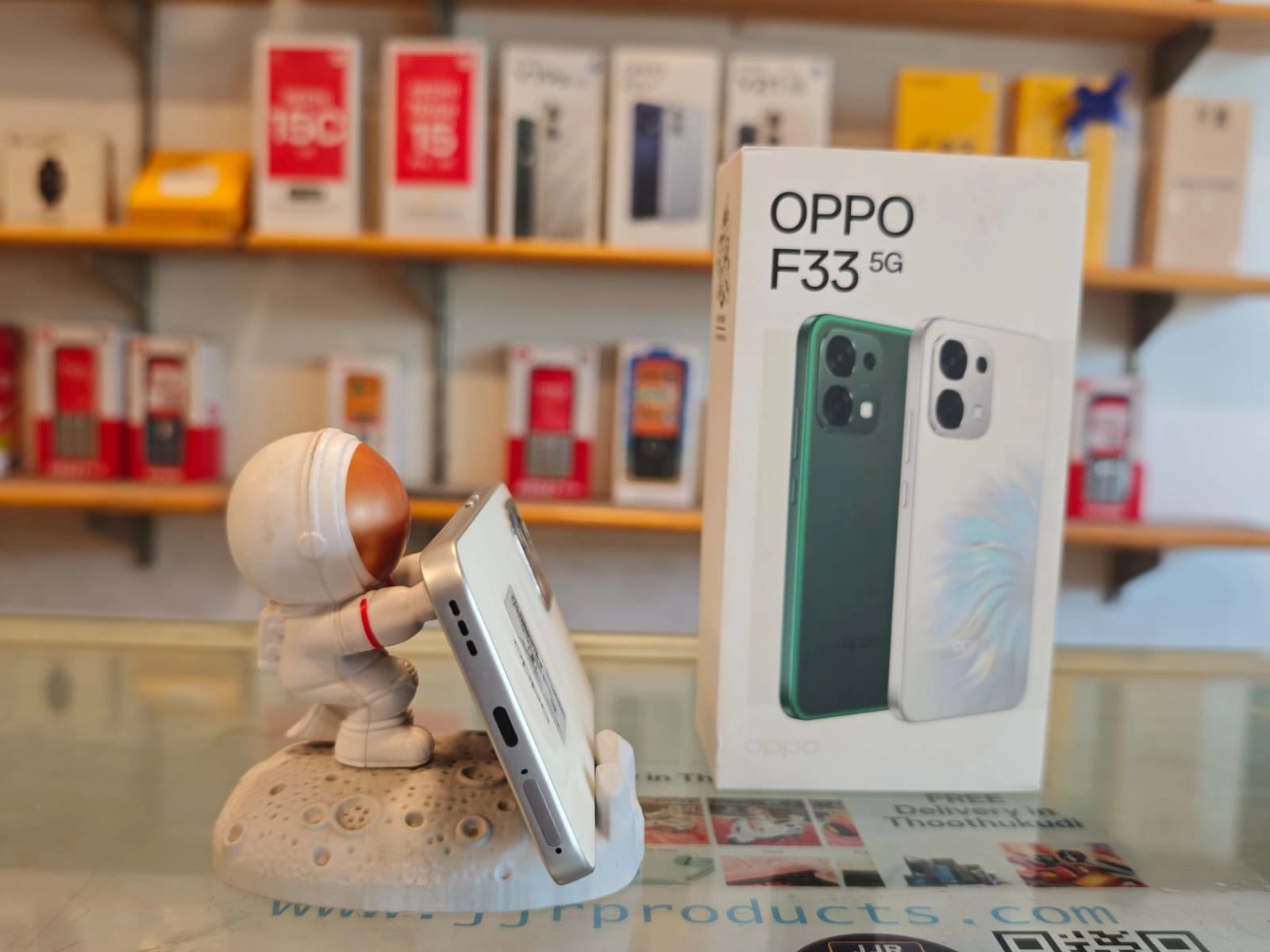 OPPO F33 5G Pearl White smartphone displayed with retail box, featuring 50MP AI dual rear camera, 16MP selfie camera, Dimensity 6360 MAX processor, and 7000mAh battery.