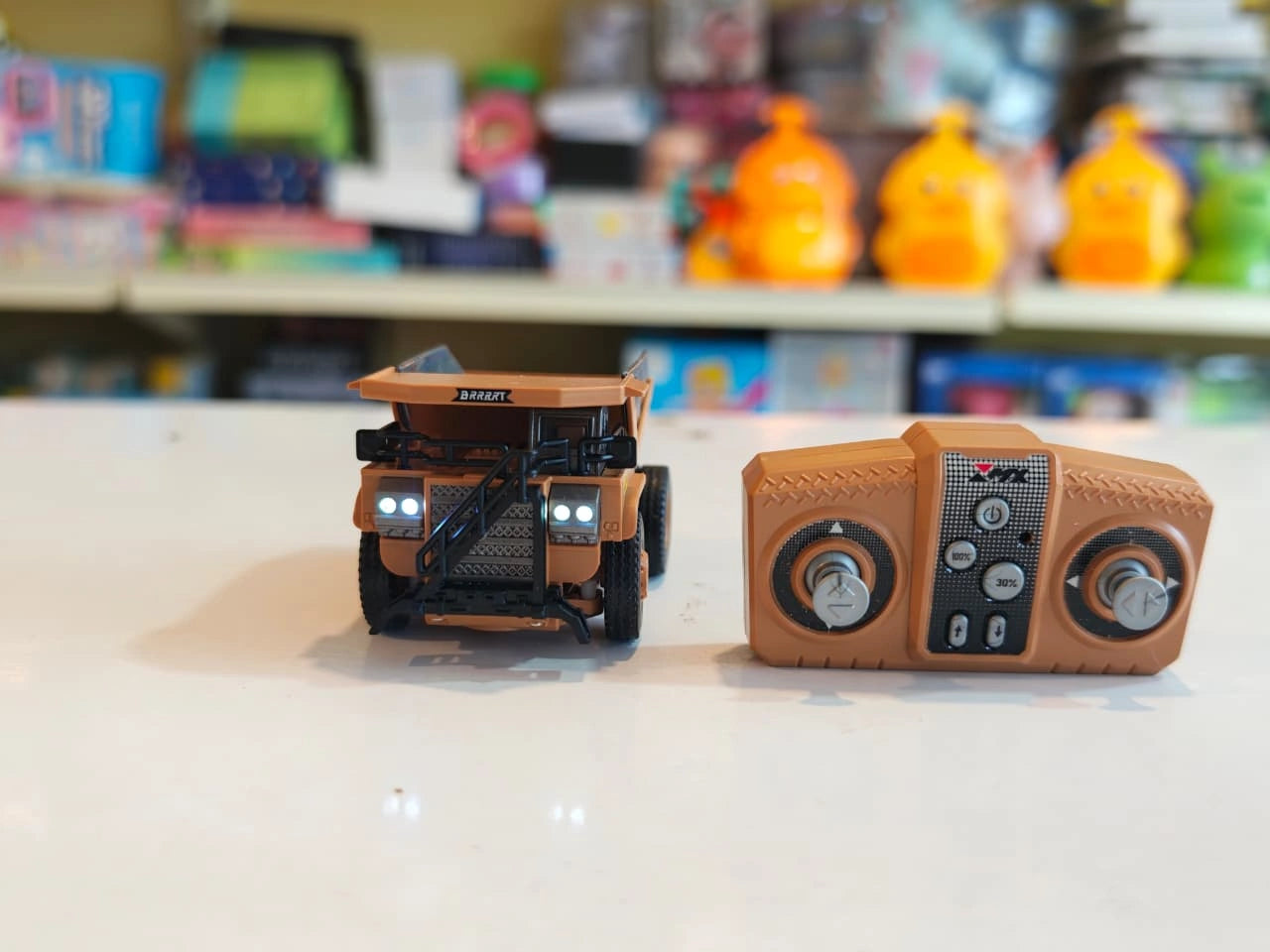 Mini RC Dump Truck featuring working dump bed, LED headlights, 2.4GHz remote control, realistic construction vehicle design and alloy parts available at Toy Trendz by JJR Mart Thoothukudi.