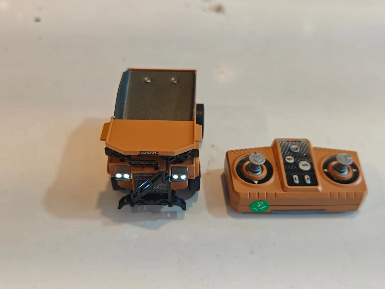 Mini RC Dump Truck featuring working dump bed, LED headlights, 2.4GHz remote control, realistic construction vehicle design and alloy parts available at Toy Trendz by JJR Mart Thoothukudi.
