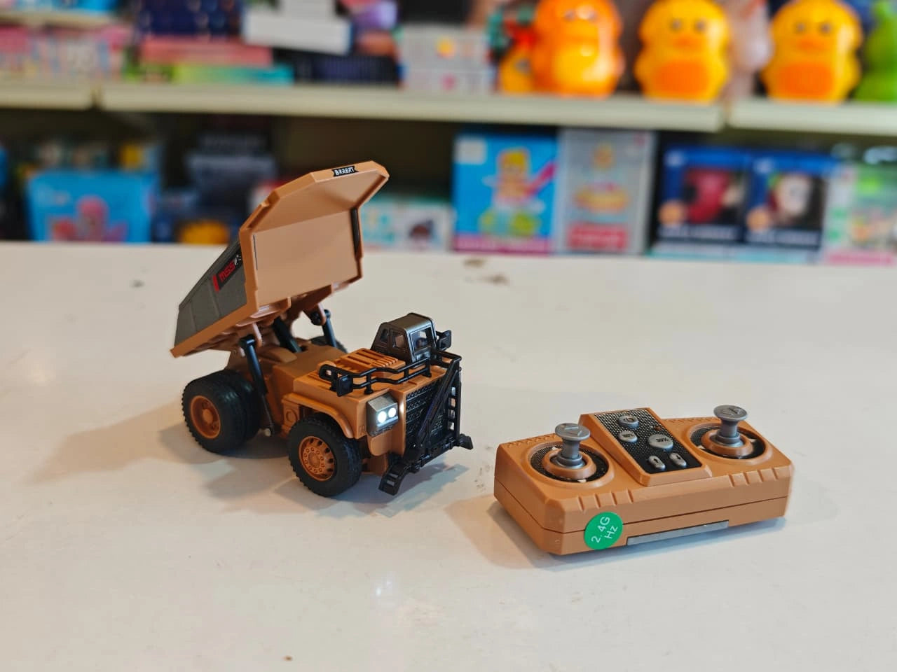 Mini RC Dump Truck featuring working dump bed, LED headlights, 2.4GHz remote control, realistic construction vehicle design and alloy parts available at Toy Trendz by JJR Mart Thoothukudi.